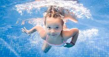 a happy child swiming under water